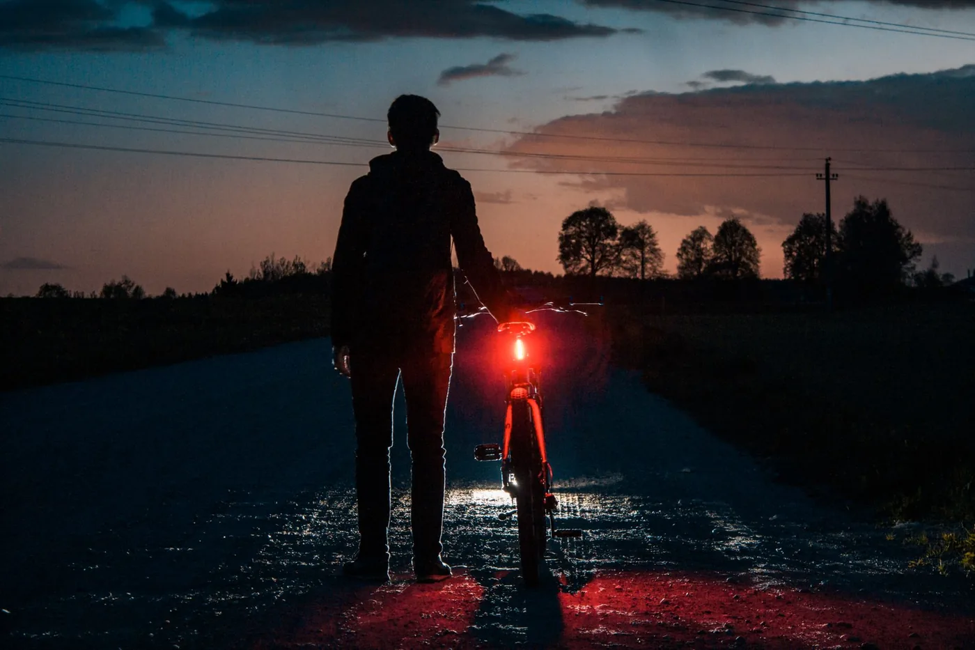 Cyklista se zadním světlem za soumraku